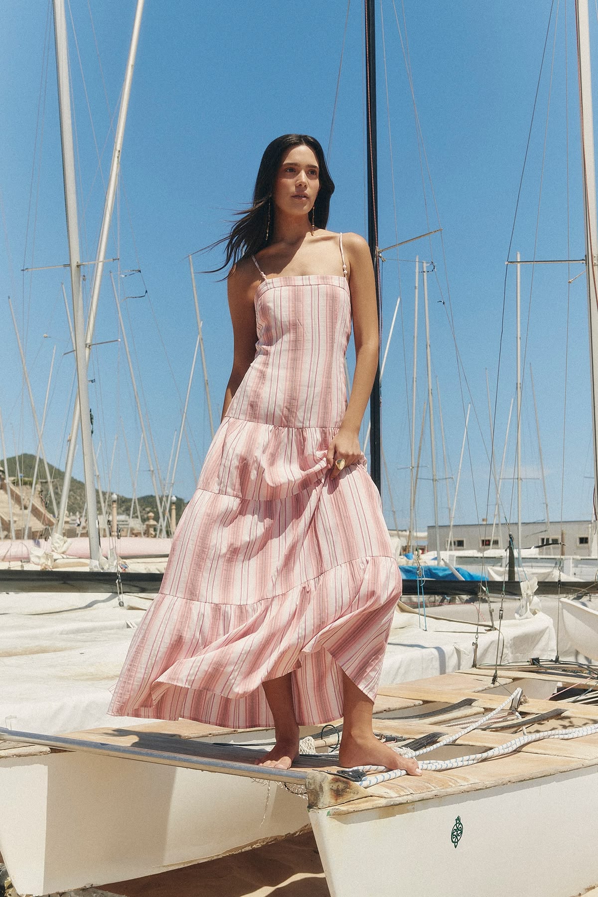 Woman wearing a flowing pink summer dress near the marina